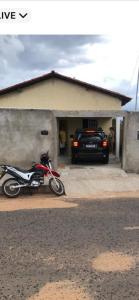 a motorcycle parked in front of a garage with a car at Casa cidade Pedro II PI in Pedro II