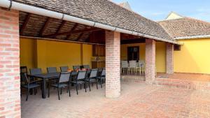 a patio with a table and chairs on a building at Rusticca M- slavonska kuća in Rokovci
