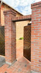 an entrance to a brick building with a wooden gate at Rusticca M- slavonska kuća in Rokovci +12 photos