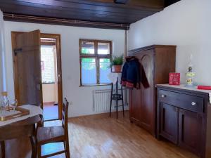 a room with a kitchen with a table and a chair at Rusticca M- slavonska kuća in Rokovci