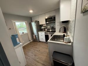 a small kitchen with white cabinets and a sink at The Downtown Loft in Fairbanks