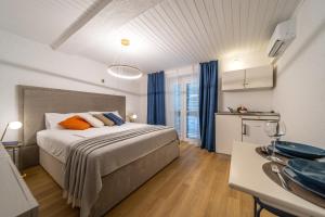 a bedroom with a large bed and a kitchen at Beach Suite Nina in Rab