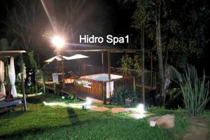 a hot tub in a garden at night at Pousada do Rodrigo in Macacos