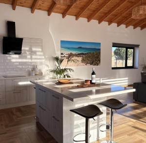 a kitchen with a island with stools and a counter top at Casa El Cachorro in La Oliva