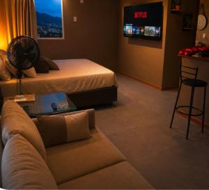 a hotel room with a bed and a couch at Aconchego Valença & Spa in Nova Friburgo +32 photos