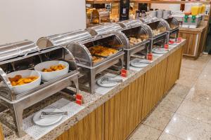 a buffet line with plates and bowls of food at Savana Hotel in Uberlândia