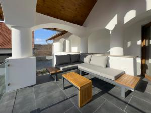 a living room with a couch and a table at Veloralux Apartman in Kovácsszénája