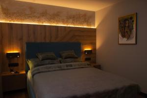 a bedroom with a large bed with a blue headboard at Veloralux Apartman in Kovácsszénája +25 photos