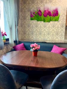 a wooden table with a vase of flowers on it at Котедж Villagoria з теплим басейном in Slavske +20 photos