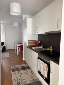 a kitchen with white cabinets and a black counter top at Cozy Apartment in Graz