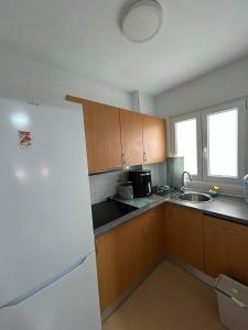 a kitchen with a white refrigerator and a sink at Mirador da Guarda in A Guarda +4 photos