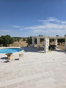 a patio with a pool and a pergola next to at Casa Loredana in Putignano