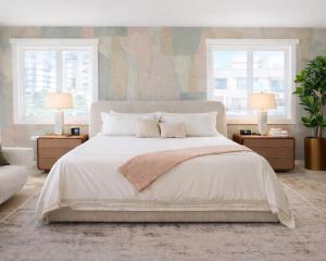 a bedroom with a large bed with two windows at Coral Princess Hotel in San Juan +58 photos