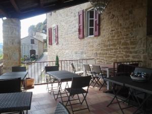 a patio with tables and chairs and a brick building at La Terrasse de Peyre in Comprégnac