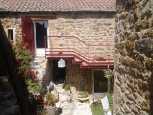 an outside view of a stone building with a balcony at La Terrasse de Peyre in Comprégnac