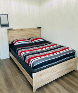 a wooden bed with two red pillows on it at The Sunshine Studio - No Smoking in Orlando