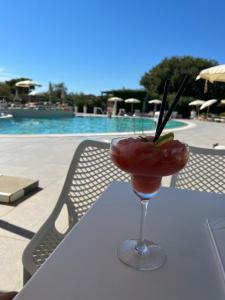 a drink sitting on a table next to a pool at Four bedroom Beach House Amaya Medulin in Medulin