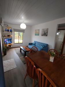 a living room with a table and a blue couch at casa Andylu in Punta Del Diablo