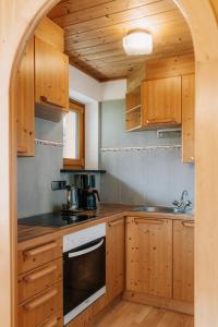 a kitchen with wooden cabinets and a sink at Weifer Biobauernhof in Prägraten +9 photos
