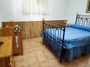 a bedroom with a bed with a blue bedspread at Casa Rural Paraje La Venta in Pliego +34 photos