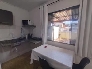 a room with a white table and a window at Casa completa - Ótimo Custo-benefício in Itajaí
