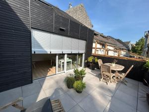 a patio with a table and chairs on a house at Chambre haute in Eupen