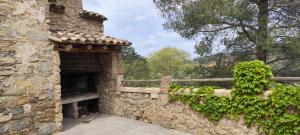 a stone building with a stone wall and a fence at Casa Sabinar in Navajas