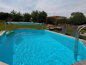 a swimming pool in a backyard with a blue pool at Les volets bleus in Cierges