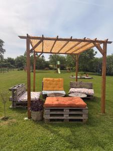 a wooden pergola with several beds in a field at Les volets bleus in Cierges