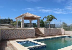 a swimming pool with a gazebo and a gazebo at Casa Rural Paraje La Venta in Pliego