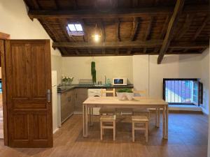 a kitchen with a wooden table and a table and chairs at Casa Piedad in Allence