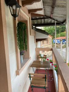 a patio with two benches and a table on a balcony at Casa Piedad in Allence