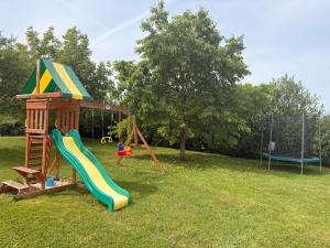 a playground with a slide and a play structure at Les volets bleus in Cierges