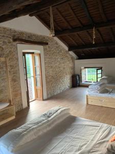 a bedroom with a bed and a stone wall at Casa Piedad in Allence