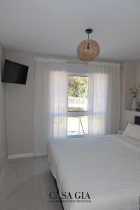 a white bedroom with a bed and a window at CASA GIA l Luxury apartment Benidorm in Benidorm +101 photos