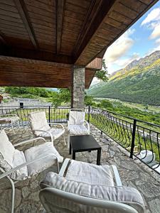a patio with white chairs and a table and a view at Kulla e Andrrave in Ducaj
