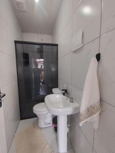 a white bathroom with a toilet and a sink at Casa completa - Ótimo Custo-benefício in Itajaí +6 photos