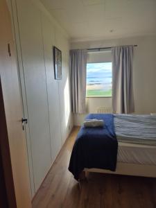 a small bedroom with a bed and a window at Miðjanes Reykhólahrepp in Reykhólar