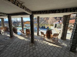 eine Terrasse mit Stühlen und einem Tisch sowie ein Pool in der Unterkunft Cozy "Vila Koki" with Private Pool and Lake Surrounded by Nature in Gabrovo
