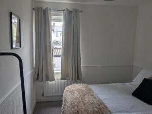 a bedroom with a bed and a window at Grange Retreat in Pontnewydd