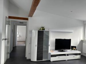 a living room with a television on a white cabinet at Ferienwohnung Roller in Endingen
