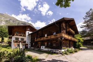 a large wooden building in front of a mountain at Weifer Biobauernhof in Prägraten