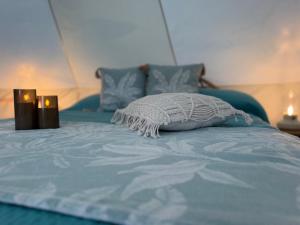 a blue bed with a pillow on top of it at La Cera Farm Camping B&B in Santa Teresa Gallura