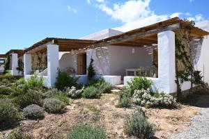 a home with a pergola in a garden at Pambelos Lodge in Koufonisia