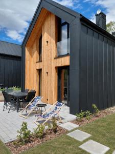 a black house with a table and chairs at Brzozowy Rożnów in Rożnów