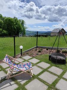 a swinging chair in a yard with a fire pit at Brzozowy Rożnów in Rożnów