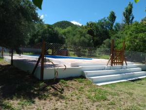 a swimming pool with white steps next to a fence at Lo de Chimila in San Javier