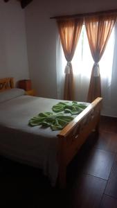 a bed in a bedroom with curtains and a window at Lo de Chimila in San Javier