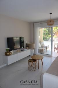 a white living room with a tv and a couch at CASA GIA l Luxury apartment Benidorm in Benidorm