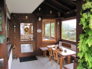 - une salle à manger avec une table, des chaises et des fenêtres dans l'établissement Gästehaus Stöckl, à Schönau am Königssee